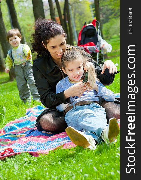 Mother with children resting and playing in the park