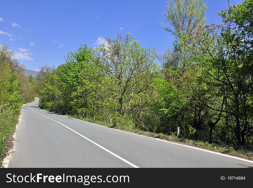 Curved road under cloudy sky