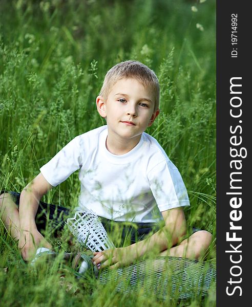 The boy with a racket against a green grass