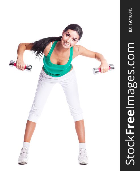Beautiful young woman with dumbbells, against white background