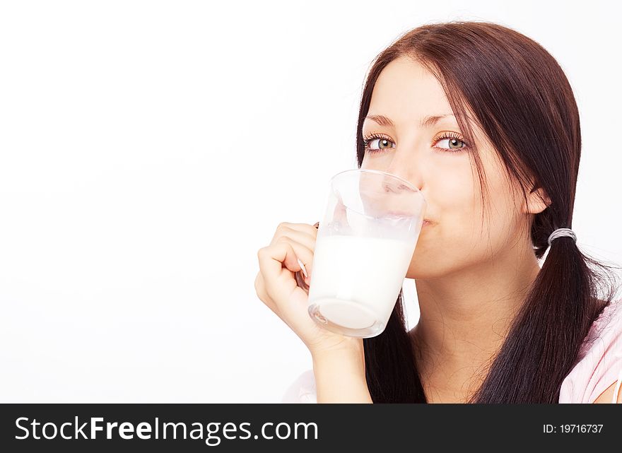 Pretty brunette girl drinking milk on the bed at home, a lot of copy space for your text to the left