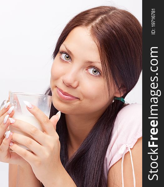 Pretty brunette girl drinking milk on the bed at home