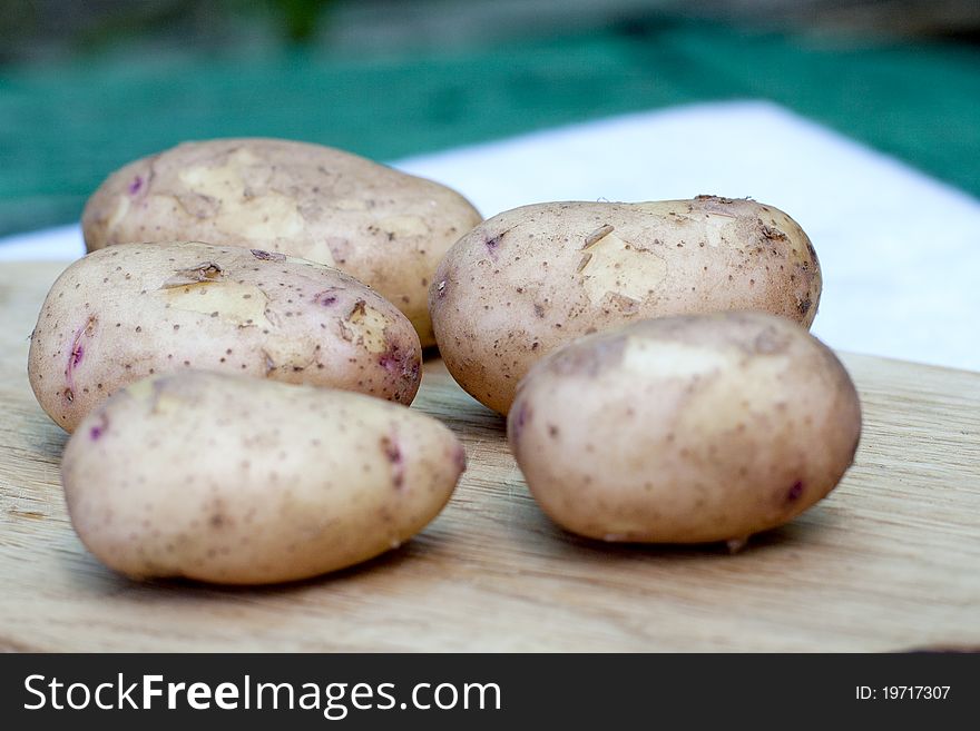 New potatoes are laid out on a board, on a background nature