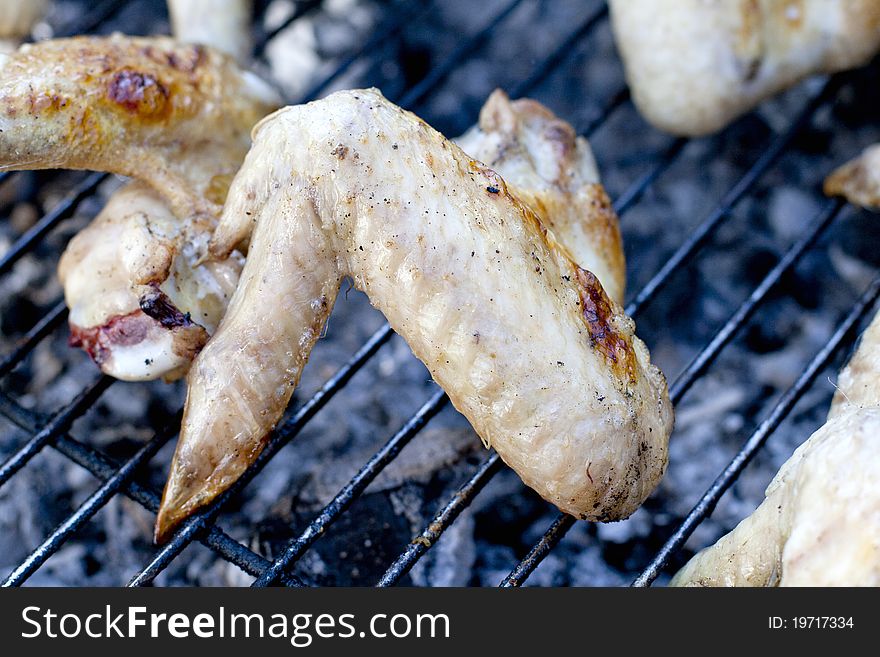 Chicken wings on Barbekyu on a grate with coals