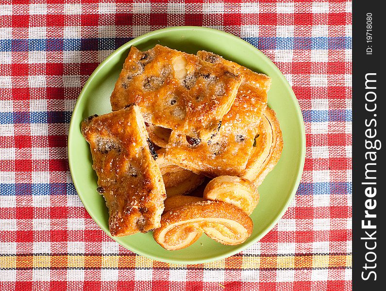 Sweet cakes on plate, tablecloth