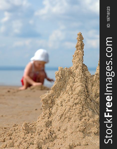 The sandcastle and playing child