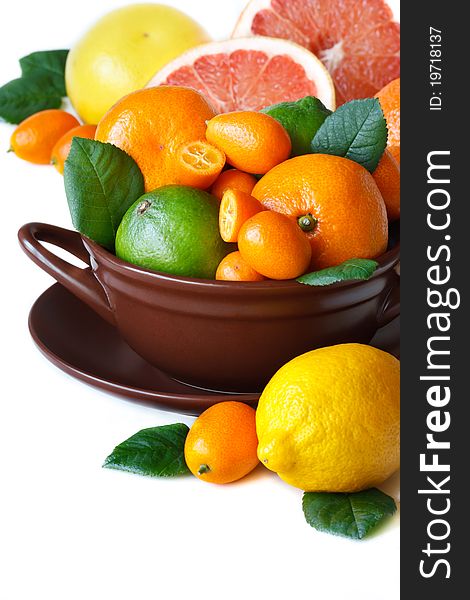 Colorful citrus fruit in a brown ceramic bowl. Colorful citrus fruit in a brown ceramic bowl.