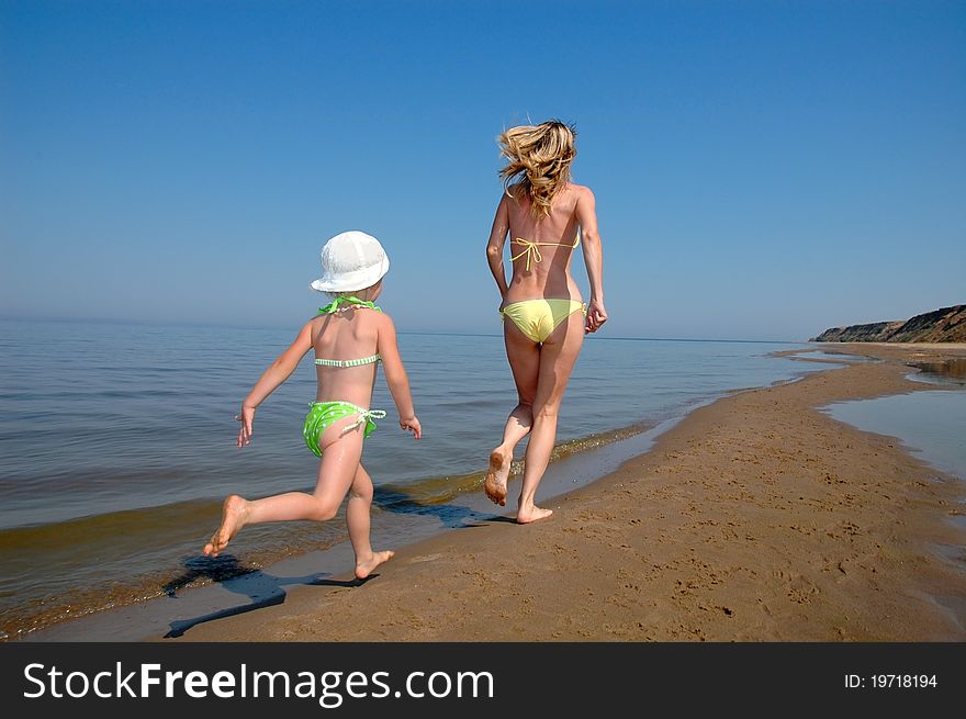 Mother with child have fun on the beach. Mother with child have fun on the beach
