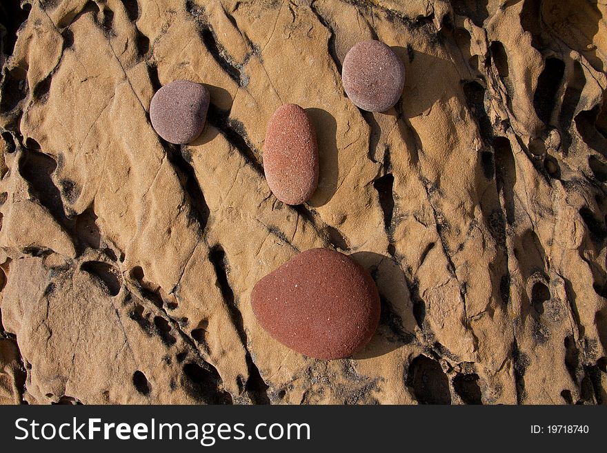 Round stones posed over a rock forming a stylized face. Round stones posed over a rock forming a stylized face