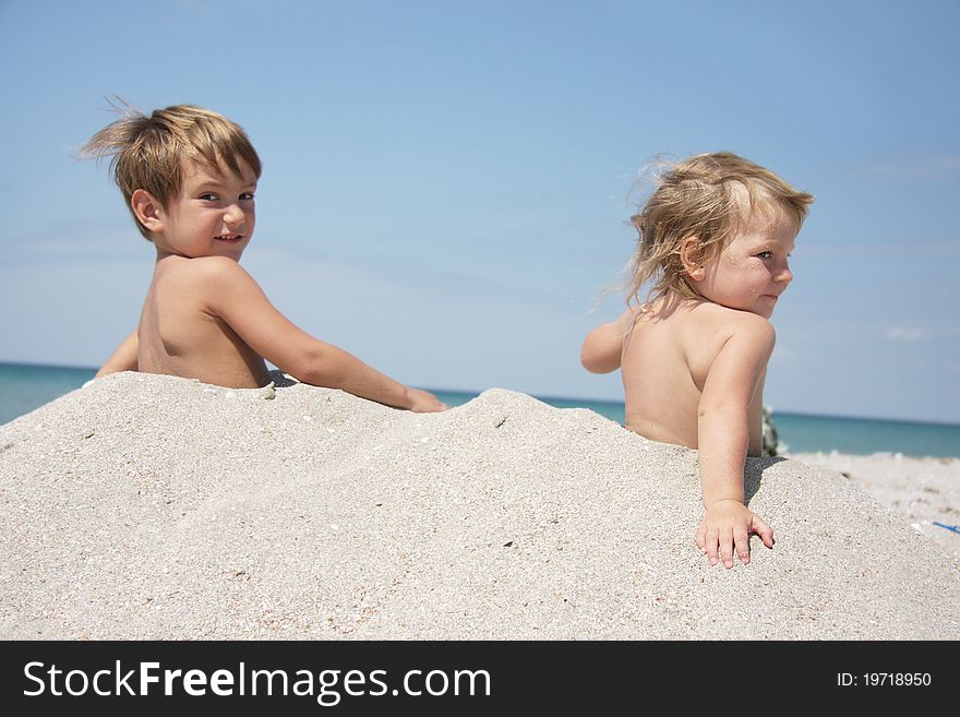 Two children playing in sand on beach. Two children playing in sand on beach