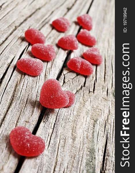 Red heart shaped jelly sweets on a rustic background