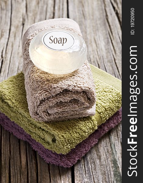 Fresh towels and glycerine soap on a rustic wooden surface. Fresh towels and glycerine soap on a rustic wooden surface