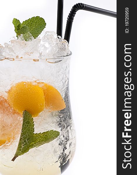 Cocktail with an orange and a lemon with ice slices in a transparent glass close up. Cocktail with an orange and a lemon with ice slices in a transparent glass close up