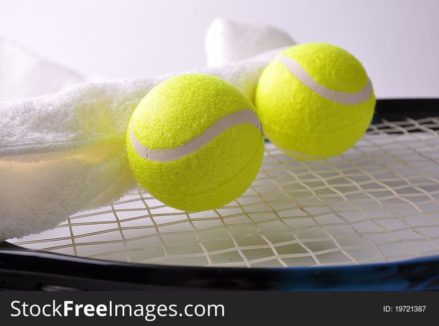 Two tennis balls and white towel on the racket isolated on white background.