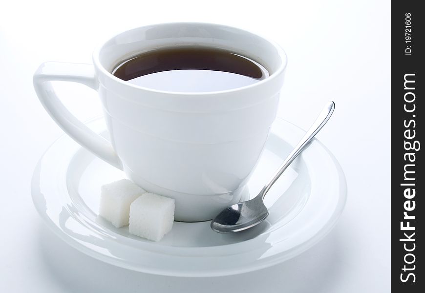 Tea cup with spoon and sugar cubes