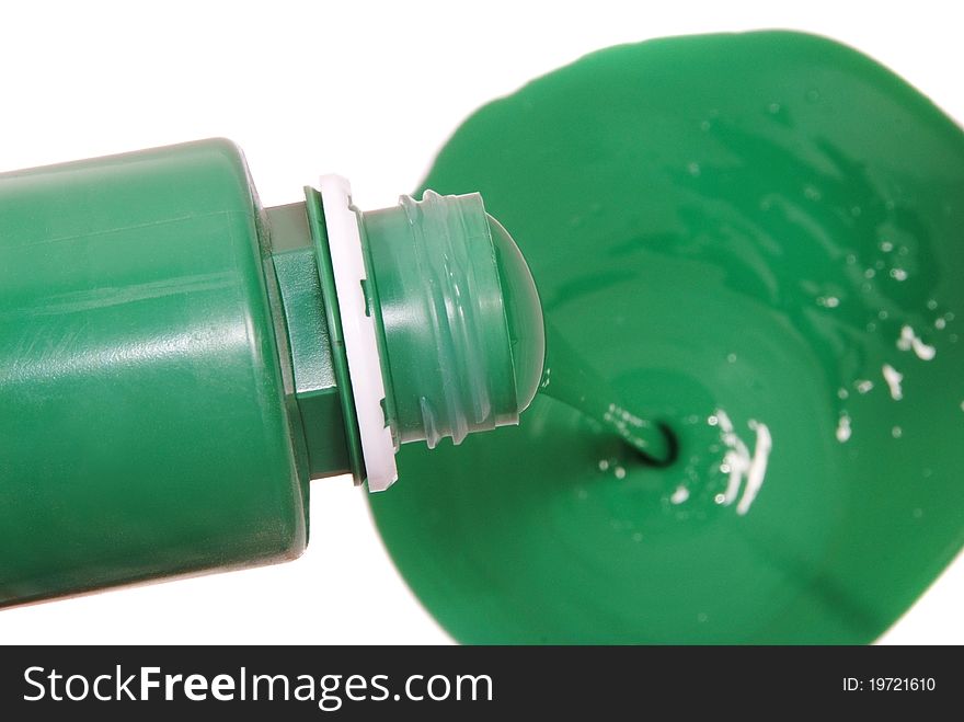 Green paint pouring in bucket isolated on white