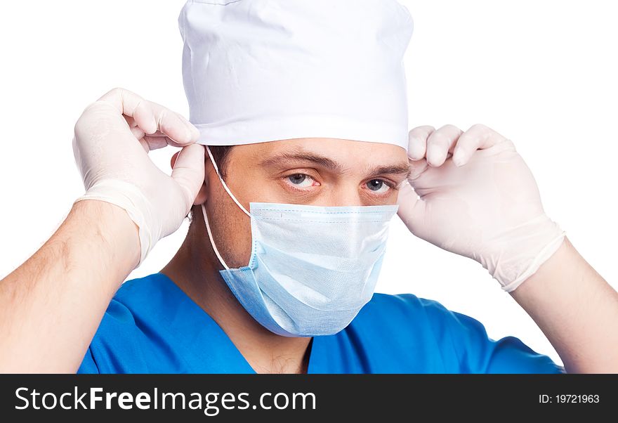 Portrait of a doctor putting on a mask and blue uniform. isolated on white background