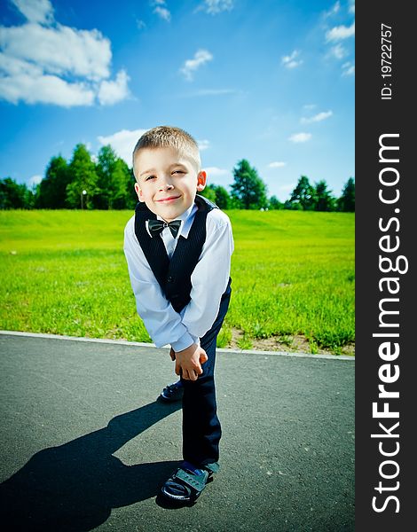 Little boy in a shirt and vest in park