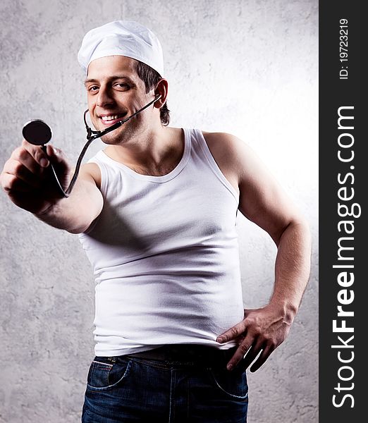 Humorous portrait of a young muscular doctor with a stethoscope, against the old wall. Humorous portrait of a young muscular doctor with a stethoscope, against the old wall