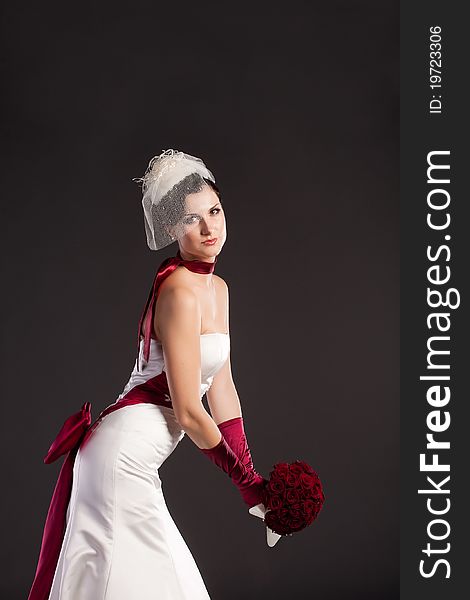 Beautiful bride in wedding dress with bouquet in studio