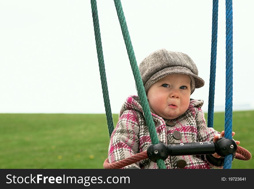 Sad baby girl on a swing