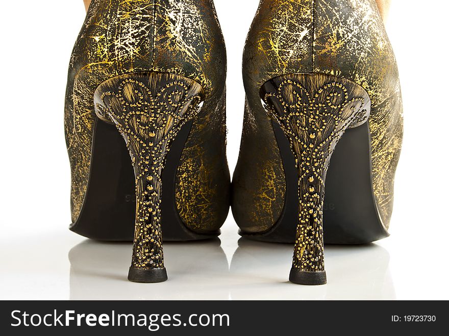 A pair of golden high-heeled shoes. Rear view. A pair of golden high-heeled shoes. Rear view.