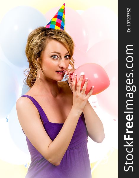 Lovely girl blowing a pink balloon indoors