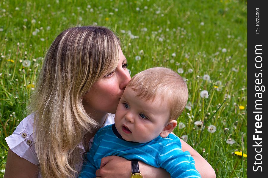 Young mother with her son on the green grass. Young mother with her son on the green grass