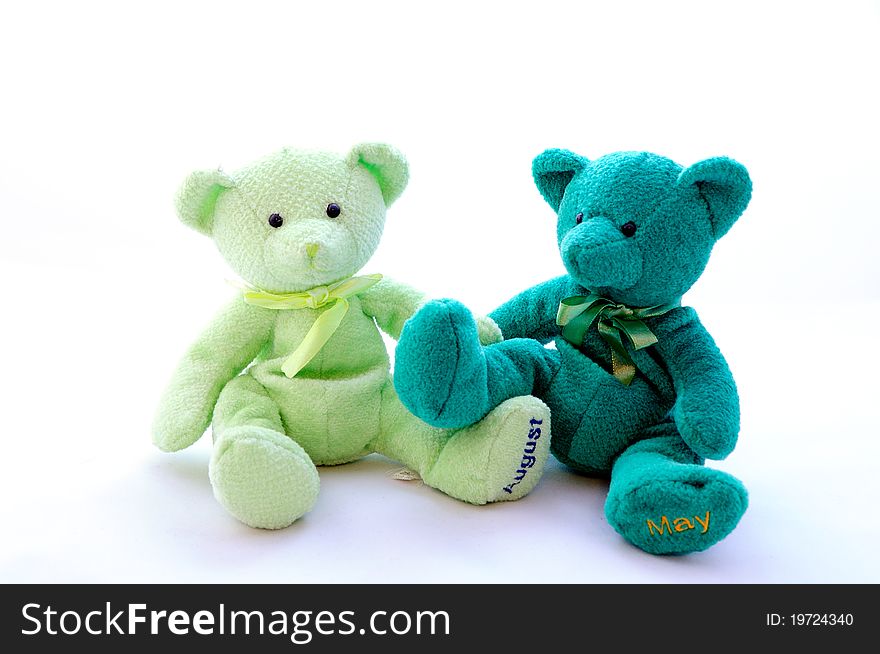 Two teddy bears sit next
