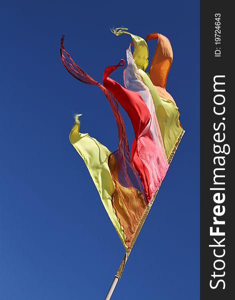 Colourful buddhistic flag against a blue sky. Colourful buddhistic flag against a blue sky