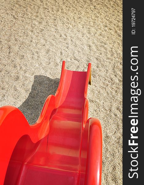 A children play at playground with red slide and sand background on holiday time. A children play at playground with red slide and sand background on holiday time.