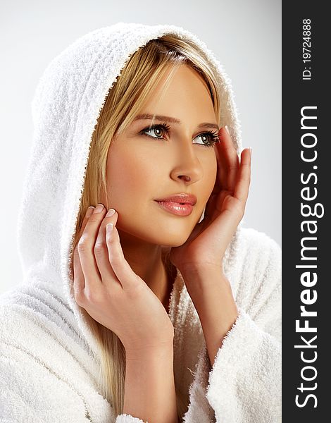 Portrait of a blond girl in a white bathrobe