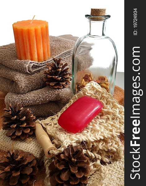 Soap, bottle, candle, towels and pine cones placed on a towels, on a white background. Soap, bottle, candle, towels and pine cones placed on a towels, on a white background