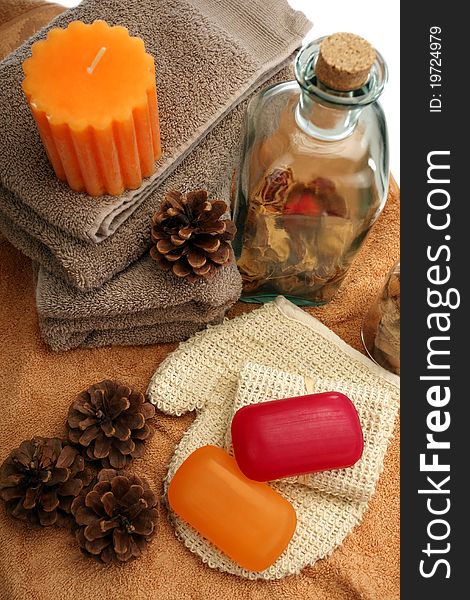 Soaps, bottle, candle, towels and pine cones placed on a towels, on a white background. Soaps, bottle, candle, towels and pine cones placed on a towels, on a white background