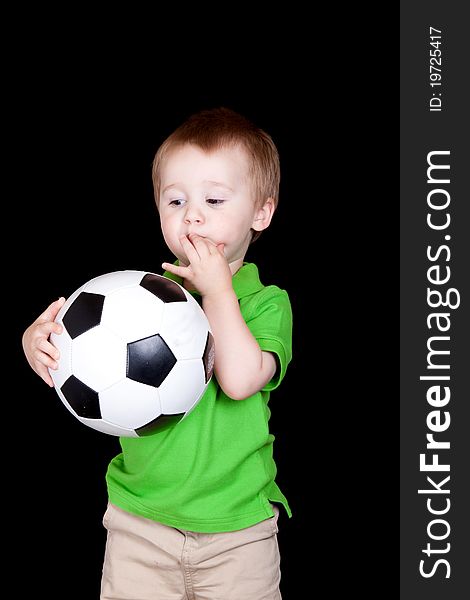 A cute child poses with his soccer ball. A cute child poses with his soccer ball.