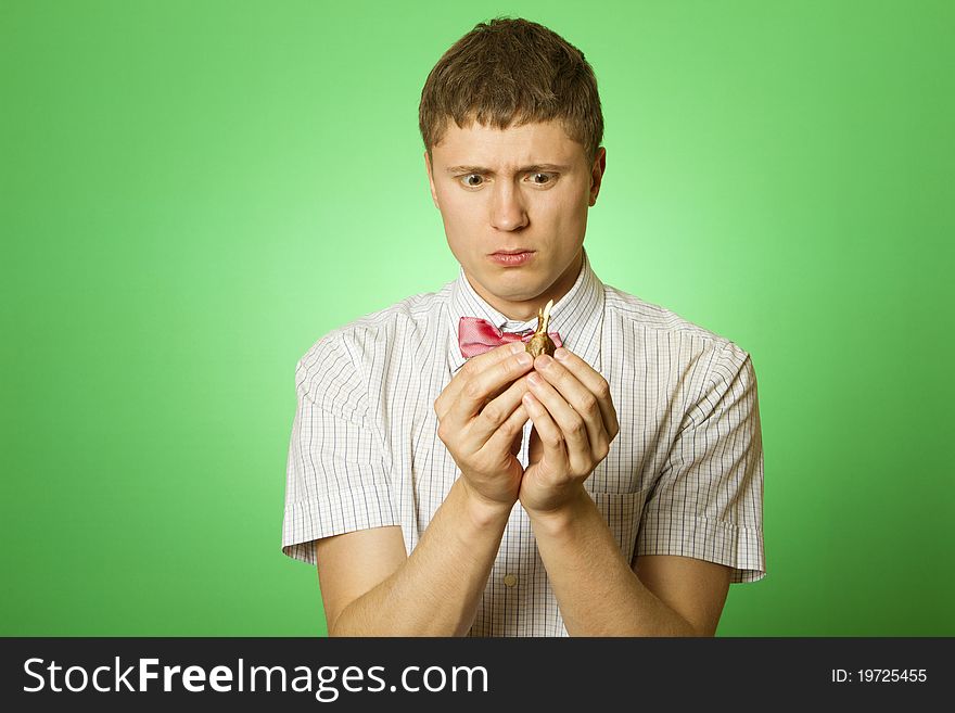 Closeup of a young man in a shirt and bow tie with a tulip bulb, thinking what to do with the onion. nerd . Parody. Closeup of a young man in a shirt and bow tie with a tulip bulb, thinking what to do with the onion. nerd . Parody