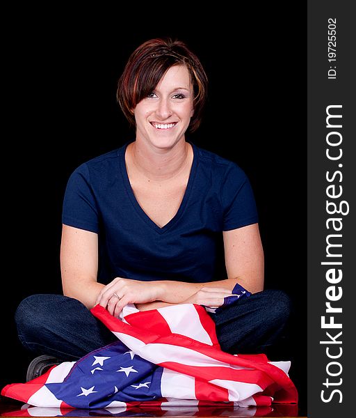 A patriotic image of a woman sitting down with the flag. A patriotic image of a woman sitting down with the flag.