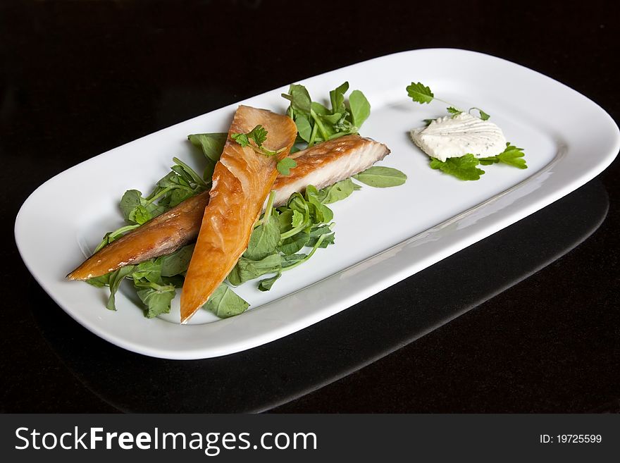 Smoked mackerel fillets on a bed of pea shoots served with a horseradish & herb mousse & garnished with mustard leaf. Smoked mackerel fillets on a bed of pea shoots served with a horseradish & herb mousse & garnished with mustard leaf