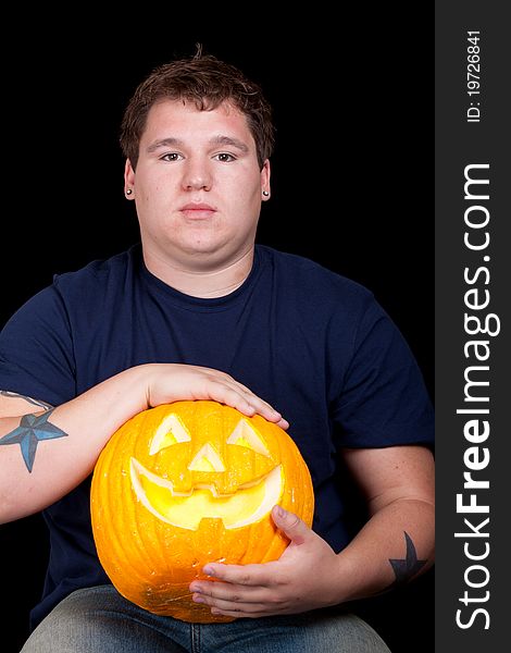 A young man holds his Halloween pumpkin. A young man holds his Halloween pumpkin.