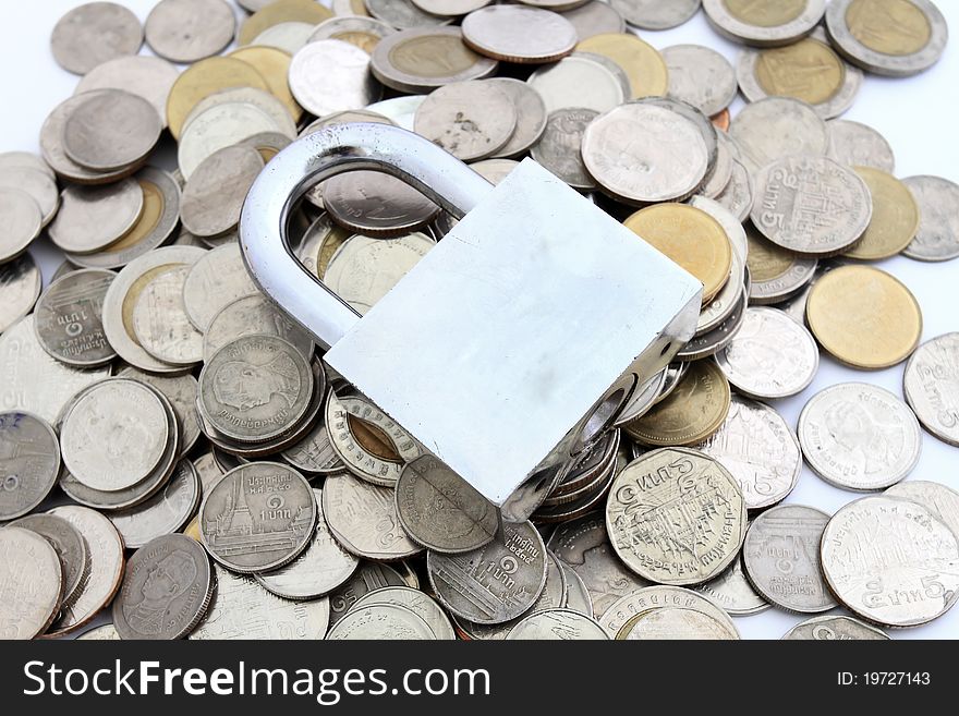 Locked Money Concept.  coins surround heavy duty locked padlock on white background.