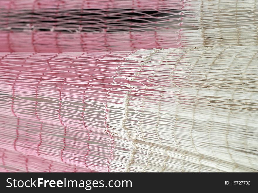 Pink and white fishing net hung out to dry