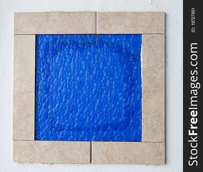 Blue glass tile framed on the wall