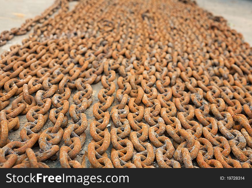 A lot of rusty metal chains lie on the deck of the ship. A lot of rusty metal chains lie on the deck of the ship