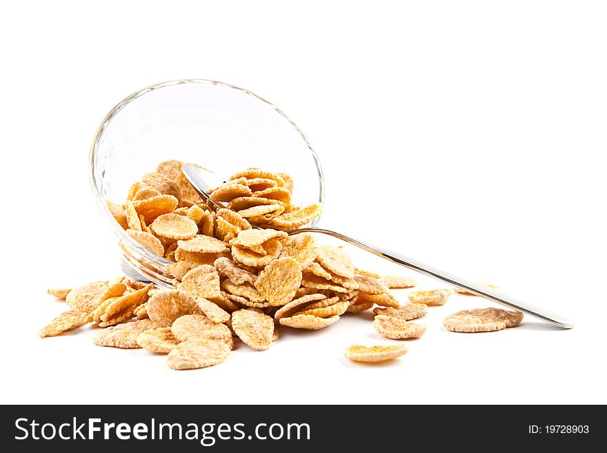 Bowl of dried cornflakes and spoon isolated on white