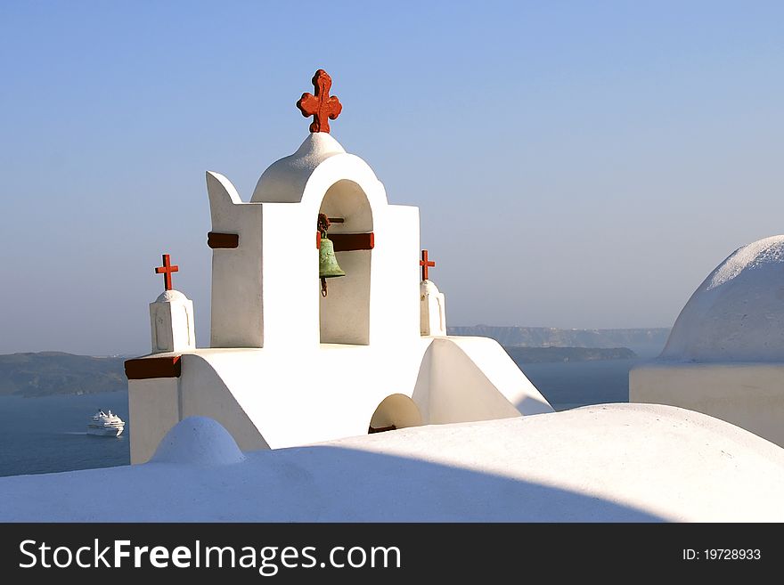 Red cross on Church bell tower on Santorini