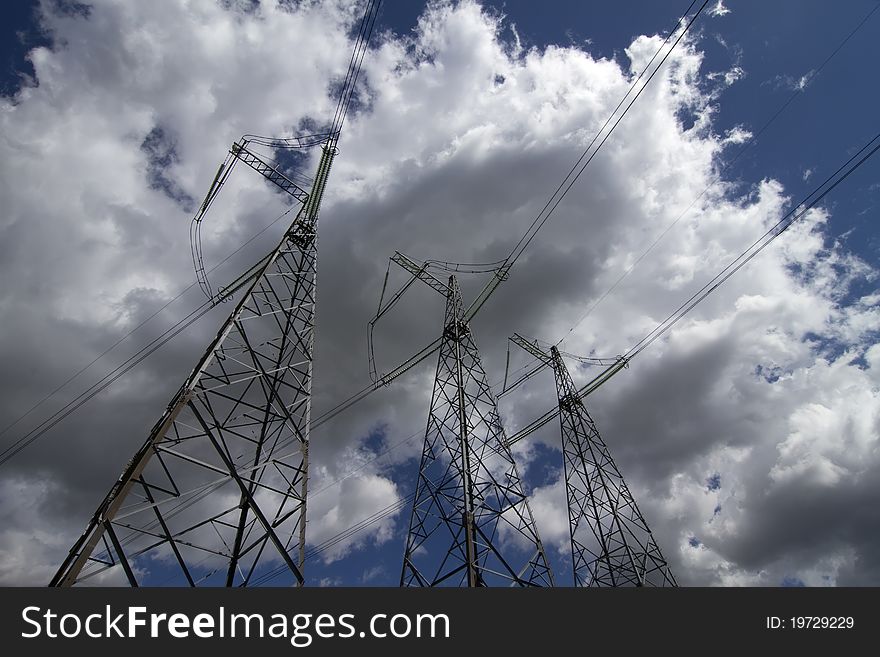 Wide angle view of high voltage power pylons on against sky. Wide angle view of high voltage power pylons on against sky