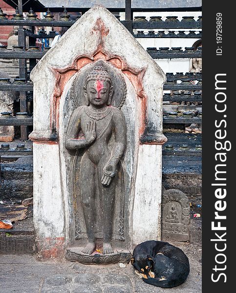 Dog sleeping under a ancient statue at Swayambhunath, Kathmandu, Nepal. Dog sleeping under a ancient statue at Swayambhunath, Kathmandu, Nepal