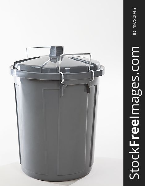 A grey wastebasket on white background