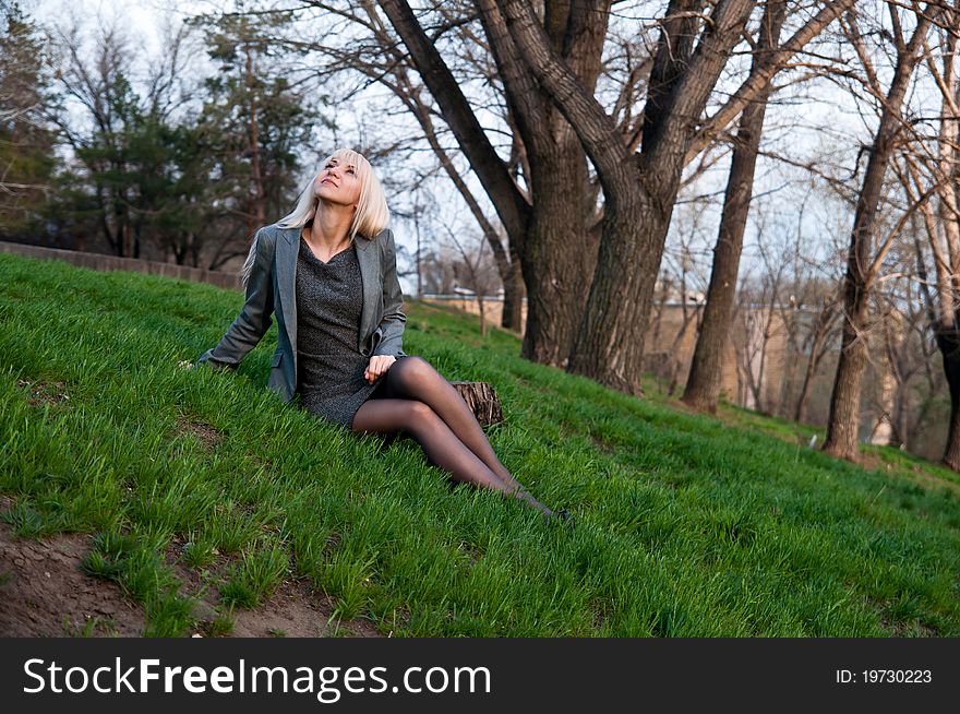 Beautiful girl sitting on the grass in the park
