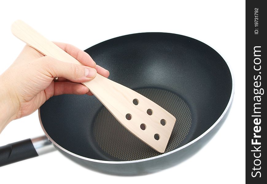 Frying pan with wooden spatula, isolated with human hand towards white background